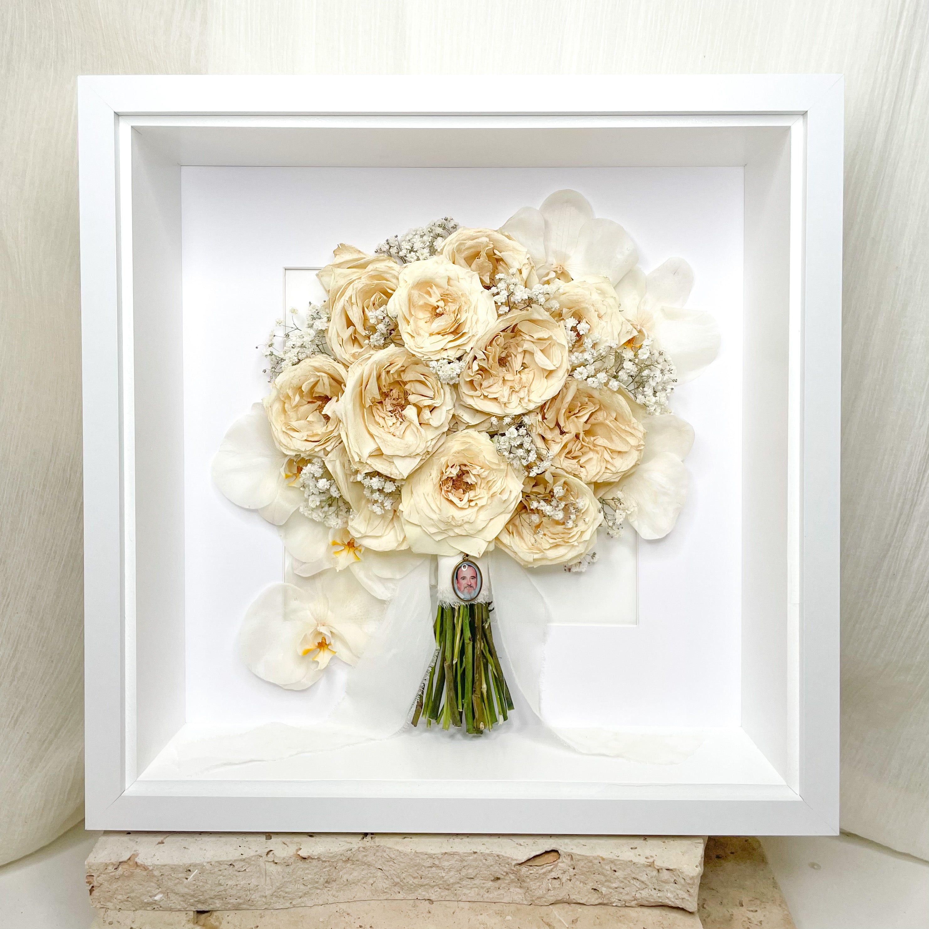 custom-flower-framing-3d-shadow-box
Preserved white rose baby’s breath wedding bouquet set in 50x50cm white 3d frame with wedding charm