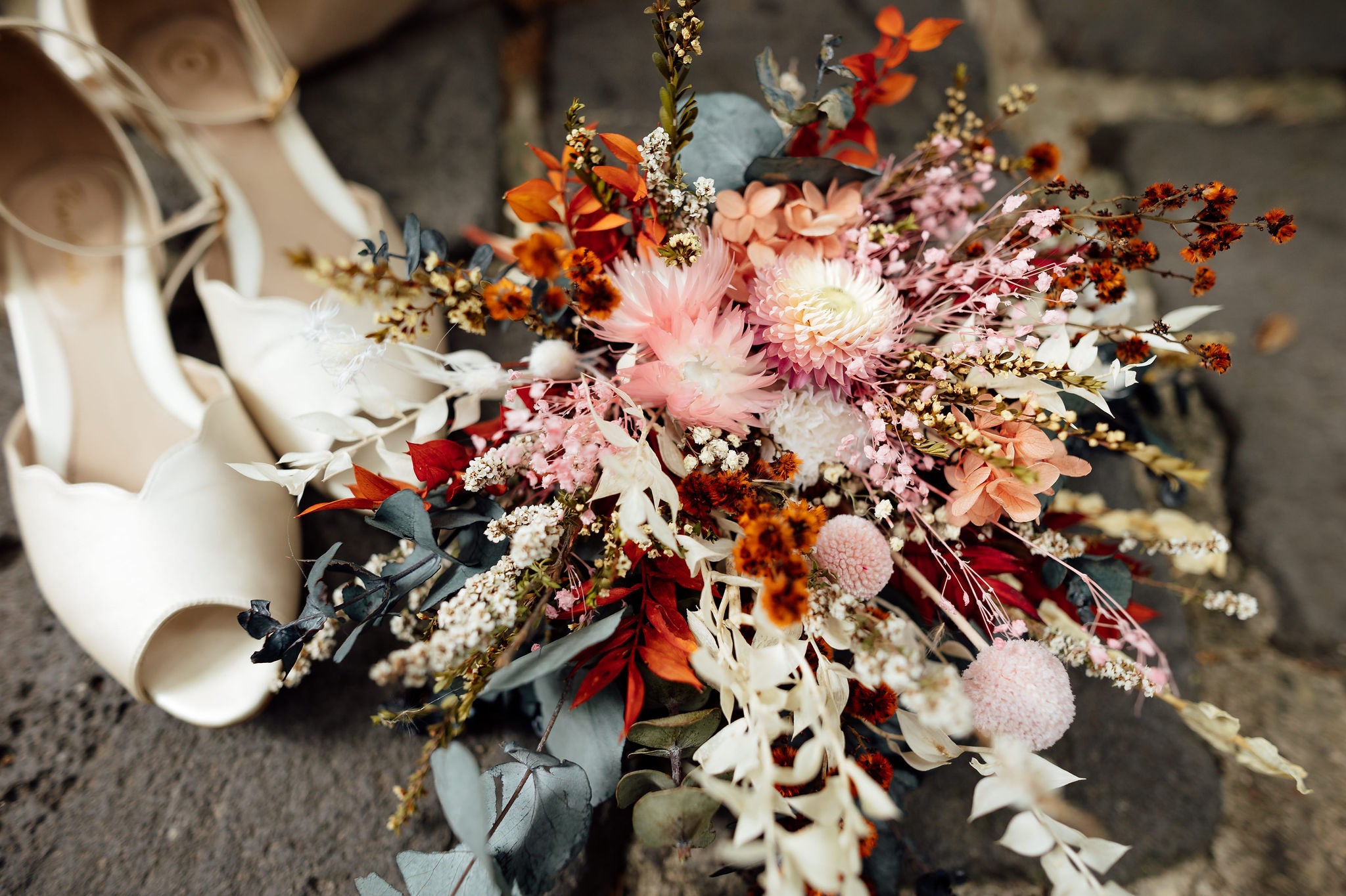 dried flower arrangement with cream wedding shoes